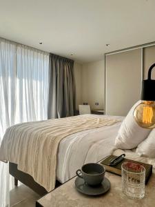 ein Schlafzimmer mit einem Bett und einem Tisch mit einer Schüssel darauf in der Unterkunft Catalina Hotel in Yerba Buena