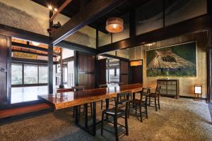 ein Esszimmer mit einem großen Holztisch und Stühlen in der Unterkunft 京都ミヤマシキテイ in Nantan city