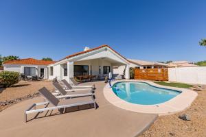 a swimming pool with lounge chairs and a house at Western Hills-Heated Pool-In Fountain Hills in Fountain Hills