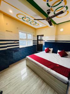 a bedroom with a large bed with red pillows on it at Kashi Inn RESIDENCY in Varanasi