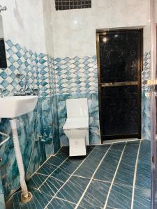 a bathroom with a toilet and a sink at Kashi Inn RESIDENCY in Varanasi