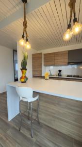 a kitchen with a white counter and a white chair at House Green el cafetal in Marquetalia