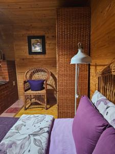 a bedroom with a bed and a chair and a lamp at Lavender Valley in Perekrestnoye