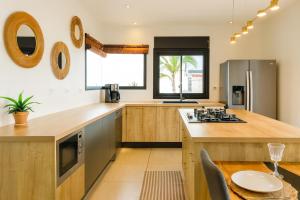 a kitchen with wooden countertops and a table with a plate on it at Villa privée - Piscine, Jacuzzi, Sauna & Hammam in Le Tampon