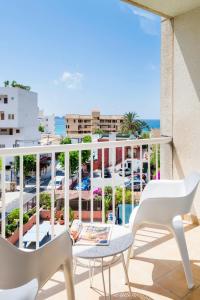 balcón con mesa, sillas y vistas al océano en Hostal Residencia Sutimar, en Paguera
