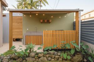 a house with a wooden fence and a garden at Villa privée - Piscine, Jacuzzi, Sauna & Hammam in Le Tampon