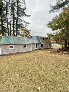 ein weißes Gebäude mit grünem Dach in einem Hof in der Unterkunft BARKER POND ESCAPE LIMIT 8 villa in Hiram