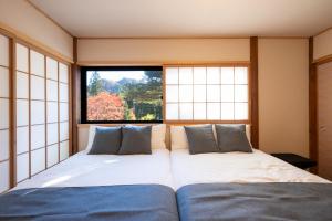 a bedroom with two beds in front of a window at Nagi GIVE 日光 in Nikko