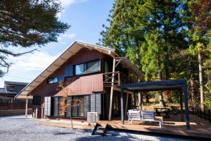 a house with a gambrel roof with two benches at Nagi GIVE 日光 in Nikko