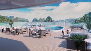 een terras met tafels en stoelen naast een zwembad bij AIME'E CRUISES - Halong Bay in Ha Long