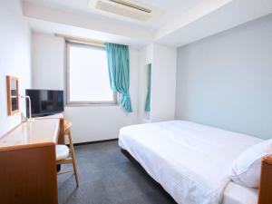 Gobōホテルグリーンヒル御坊駅前的一间卧室,里面有一张床、一张桌子和一扇窗户。