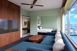 un salon avec un canapé et une télévision dans l'établissement South Gate Hotel Okinawa, à Naha