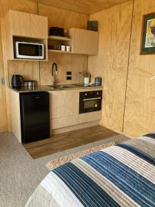 eine kleine Küche mit Spüle und Mikrowelle in der Unterkunft Seascape on Maude in Oamaru