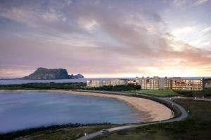 a view of a beach with buildings and the ocean at Phoenix Island in Seogwipo +64 photos