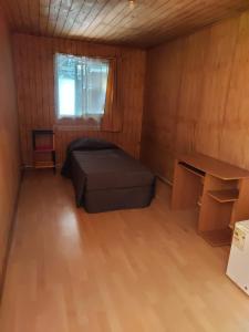 コンセプシオンにあるHabitación individual para hombres 'のベッドと机のある小さな部屋