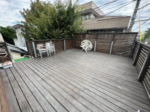 茅崎市Guest Room Chigasaki的一个带椅子和围栏的木制甲板 更多17张照片