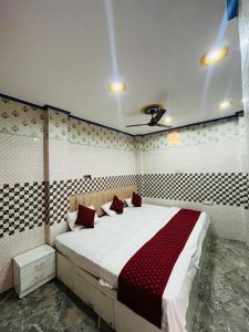 a bedroom with a large white bed with red pillows at Kashi Inn RESIDENCY in Varanasi