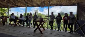 a group of people standing around a table with laptops at Zen Garden Palace in Ella