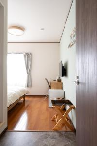 - une chambre avec un lit, une table et une porte dans l'établissement 蔵の宿, à Kamogawa 8 autres photos