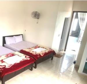 1 Schlafzimmer mit 2 Betten in einem Zimmer mit Fenster in der Unterkunft Bảo Minh Motel Đông Hà in Quang Tri + 3 Fotos