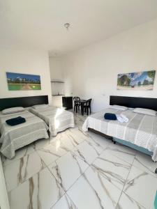 2 Betten in einem Zimmer mit Marmorboden in der Unterkunft Pousada Spa Peruíbe in Peruíbe + 78 Fotos