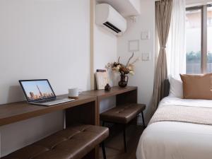 a bedroom with a desk with a laptop on it at RARE-EBISU BREEZE Apartment in Tokyo +135 photos