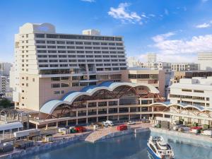 un grand bâtiment avec une rivière en face dans l'établissement South Gate Hotel Okinawa, à Naha