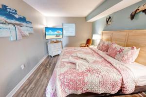 a bedroom with a bed and a tv on the wall at Condo near Barefoot Landing w beach access in Myrtle Beach +45 photos