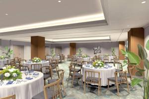 une salle de banquet avec des tables et des chaises blanches dans l'établissement South Gate Hotel Okinawa, à Naha 40 autres photos