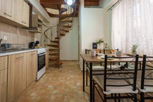 a kitchen with a wooden table and a spiral staircase at Elia Studio in Sokrákion +5 photos