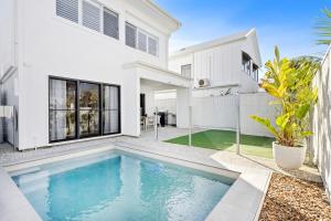 a white house with a swimming pool in front of it at Seabreeze in Kingscliff
