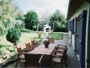 a wooden table and chairs on a patio at Maison de campagne avec 6 chambres, jardin clos, cheminée, proche de la mer, animaux acceptés - FR-1-376-3 in Wierre-Effroy +5 photos
