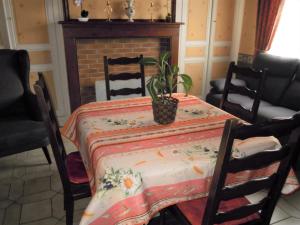 - une table à manger avec une plante au-dessus dans l'établissement Charmante Maison à Recques-sur-Hem, 2 pers, Animaux Acceptés, Jardin, Proche Calais et St Omer - FR-1-376-58, à Recques-sur-Hem