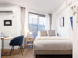 a bedroom with a bed and a desk and a window at RARE-EBISU BREEZE Apartment in Tokyo