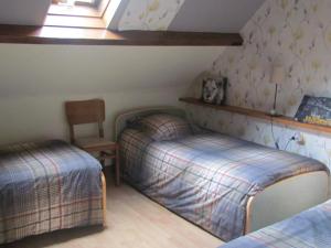 une chambre avec deux lits et une chaise dans l'établissement Maison de campagne proche Le Touquet : 7 chambres, jardin clos, jeux d’enfants, animaux acceptés - FR-1-376-94, à Hubersent 10 autres photos
