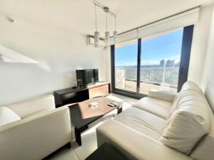 Una sala de estar con un sofá blanco y una mesa. en Stradivarius, en Punta del Este