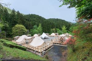 a group of tents in a field with trees at ザランタン鹿沼 in Kanuma