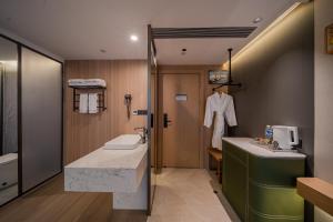 a bathroom with a sink and a toilet and a mirror at Jiting International Hotel Jiaotong University Light Rail Station in Chongqing +43 photos