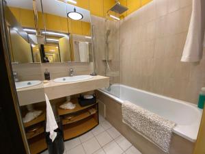 ein Badezimmer mit Waschbecken, Badewanne und Spiegel in der Unterkunft Studio moderne avec terrasse vue plage et parking à Arcachon - FR-1-474-205 in Arcachon