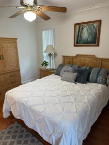 ein Schlafzimmer mit einem großen weißen Bett mit Deckenventilator in der Unterkunft Apartamento Coral springs in Coral Springs