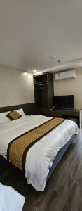 ein Hotelzimmer mit einem großen Bett und einem Fernseher in der Unterkunft Marina Hotel Lạng Sơn in Kỳ Lừa + 3 Fotos