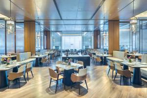 a restaurant with tables and chairs and windows at Crowne Plaza Rugao in Nantong