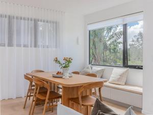 uma sala de jantar com mesa e cadeiras e uma janela em Kai Residences em Cabarita Beach