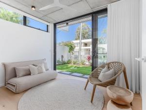 uma sala de estar com um sofá e uma cadeira em Kai Residences em Cabarita Beach