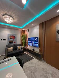 ein Wohnzimmer mit Couch und Flachbildfernseher in der Unterkunft Cozy 1 Bedroom Studio Apartment in a Gated Estate in Lagos