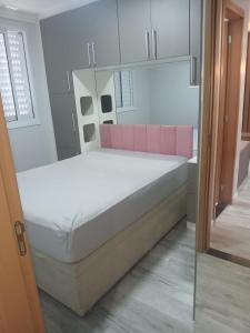 a bedroom with a large bed with pink accents at Belíssimo apartamento in Sao Paulo