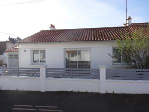 une maison blanche avec une clôture devant dans l'établissement Maison fonctionnelle près de la plage pour 6 personnes - FR-1-476-101, à La Faute-sur-Mer