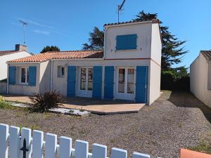 a small house with blue doors and a white fence at Maison plain-pied au calme, proche plages et commerces - FR-1-476-91 in La Faute-sur-Mer +4 photos