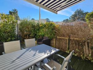 a picnic table and chairs on a patio at Maisonnette proche plage et forêt, parking privatif - FR-1-476-230 in La Faute-sur-Mer +3 photos