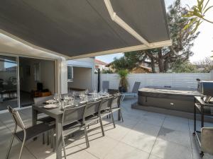 a patio with a table with wine glasses on it at Maison spacieuse 10p, proche plage, équipée, terrasse, Biscarrosse - FR-1-319-586 in Biscarrosse